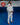 Gracie Barra professor standing on blue mats wearing the white AXIS Kimono by adidas with black belt inside a Gracie Barra school.