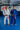 Two Gracie Barra professors standing on blue mats wearing the AXIS Kimono by adidas in white and blue colorways inside a Gracie Barra school.