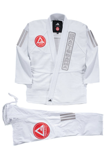 White AXIS Kimono by adidas for Gracie Barra with red Barra Shield on the jacket chest, gray adidas sleeve stripes, and matching white pants with red shield logo on a white background.