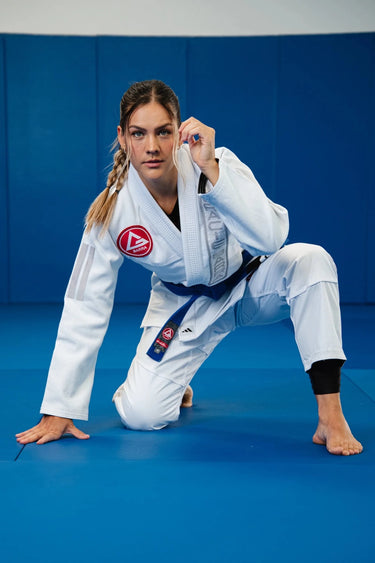 White Axis Womens Kimono by adidas worn in a low kneeling base position, showing the jacket cut and gray stripe sleeve detail.