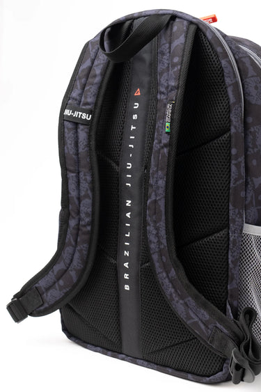 Side and back view of the Barra Beachwalk Backpack in black with Barra Da Tijuca boardwalk pattern, showing cushioned back panel, padded shoulder straps and vertical Brazilian Jiu-Jitsu branded center strap