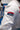Close-up of the sleeve of the white ripstop kimono jacket, showing the red Gracie Barra patch above a navy Jiu-Jitsu patch on the upper arm