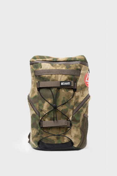 Front view of the camo Tactical GB4 Backpack Compact with bungee cord front panel, GRACIE BARRA rubber patch, red Barra shield, and side mesh pocket