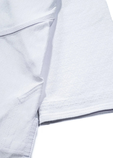 Close-up of the 40 Year Anniversary Kimono custom jacquard weave with tonal Legacy G embroidered throughout the white fabric