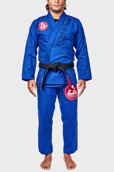 Blue Gracie Barra Continuum Kimono by Vanguard front view with the Red Shield chest patch, Gracie Barra lapel embroidery, and red thigh patch.