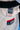 Close-up of the white ripstop kimono jacket's shoulder and lapel with a black belt draped over it, showing the navy GB woven label, red contrast stitching, and red Gracie Barra Jiu-Jitsu chest patch