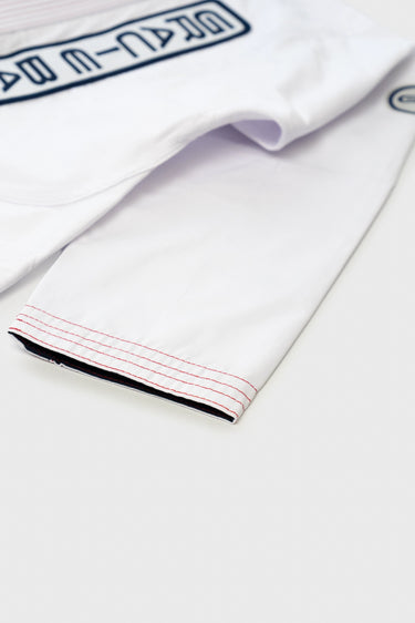 Close-up of the white ripstop kimono jacket sleeve cuff with red contrast stitching and navy Gracie Barra embroidery